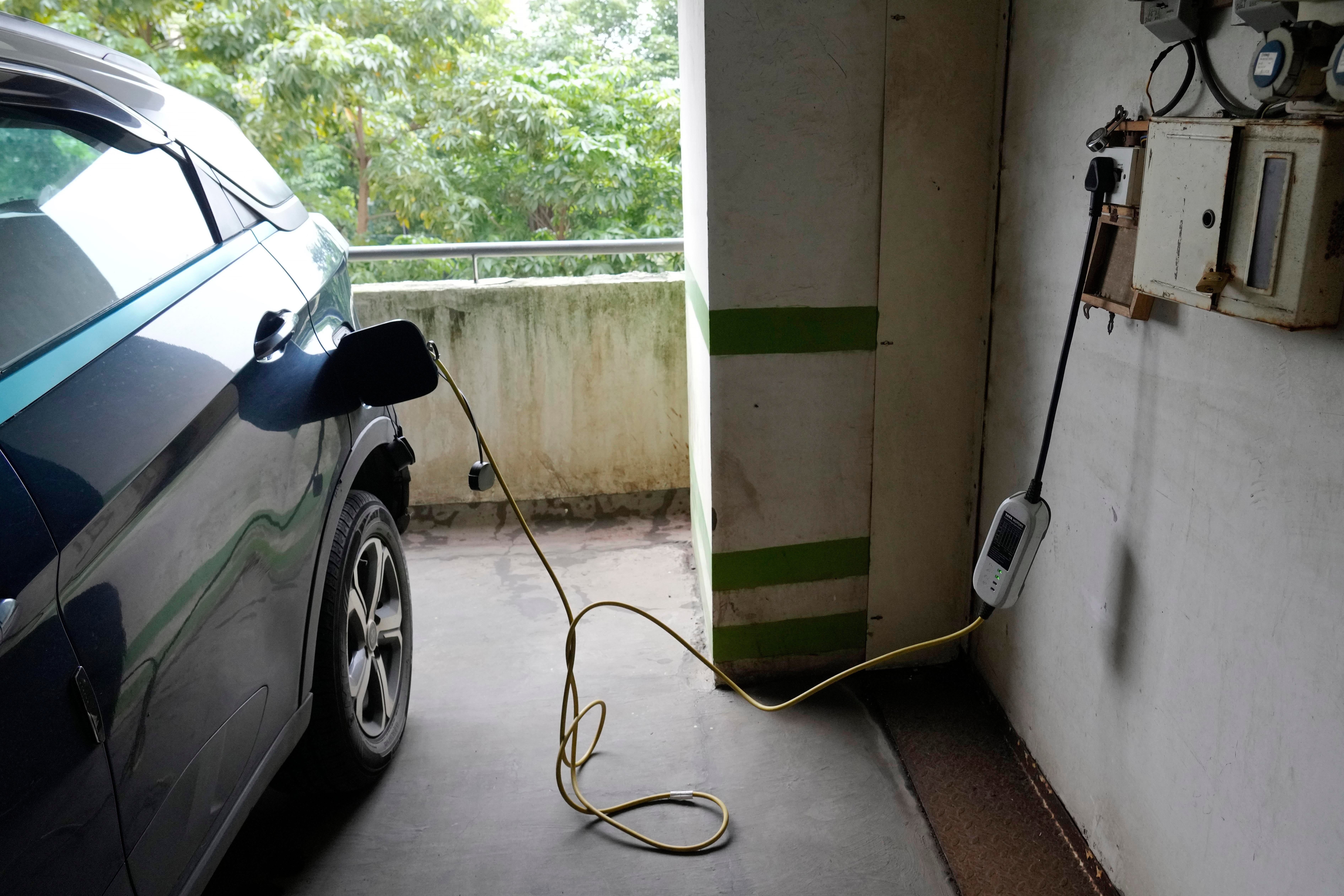 An electric car is charged at a residential building parking area in Mumbai