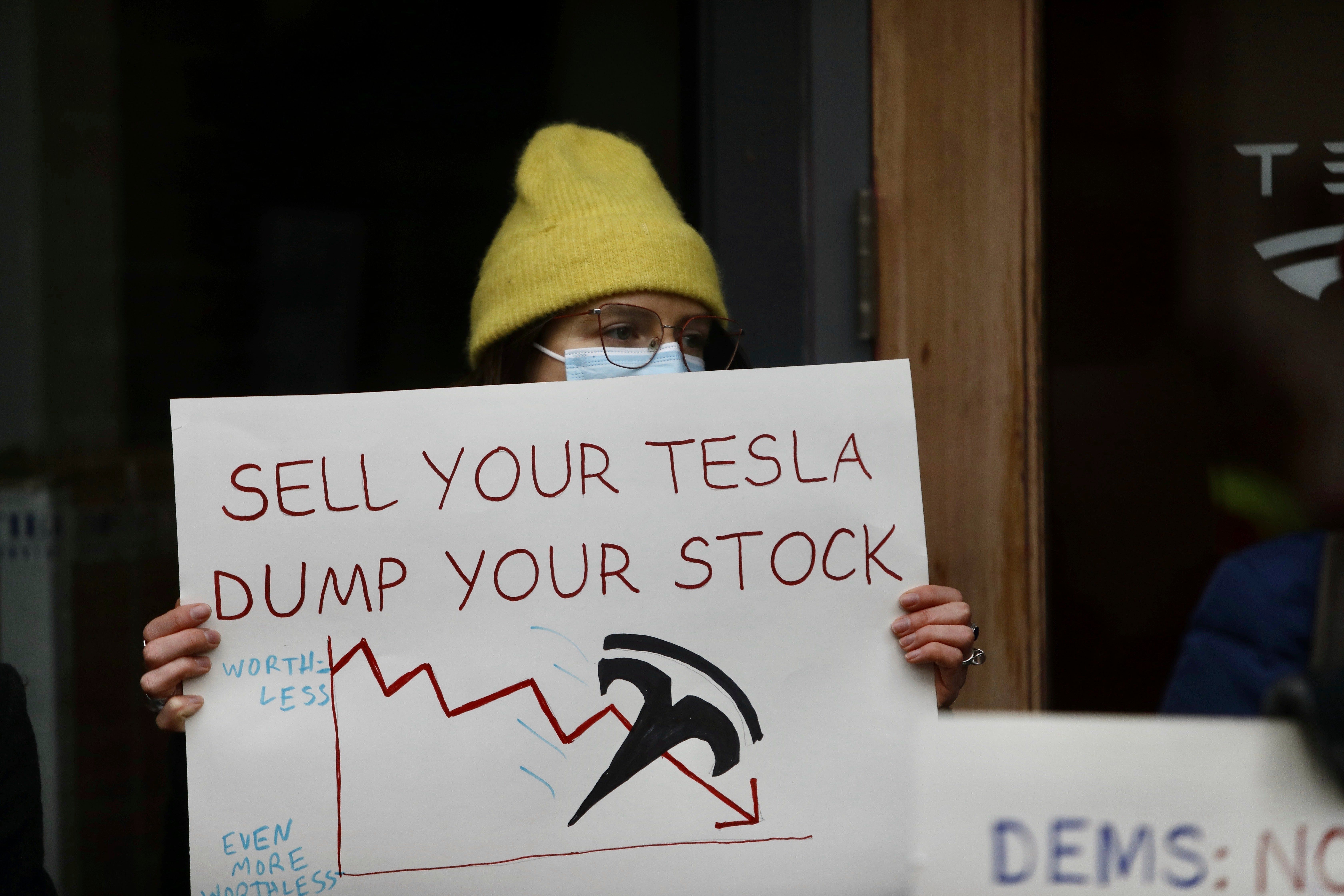 A person protesting Musk’s actions as part of the Trump administration outside of a Tesla showroom in Seattle, Washington, on February 13 2025